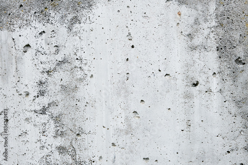 Cracked concrete wall covered with gray cement surface. Grey old wall with shabby damaged plaster or cement and brick background of an vintage dirty exfoliating plaster. Mock up.