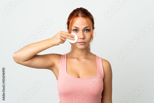 Teenager Russian girl isolated on white background with cotton pad for removing makeup from her face