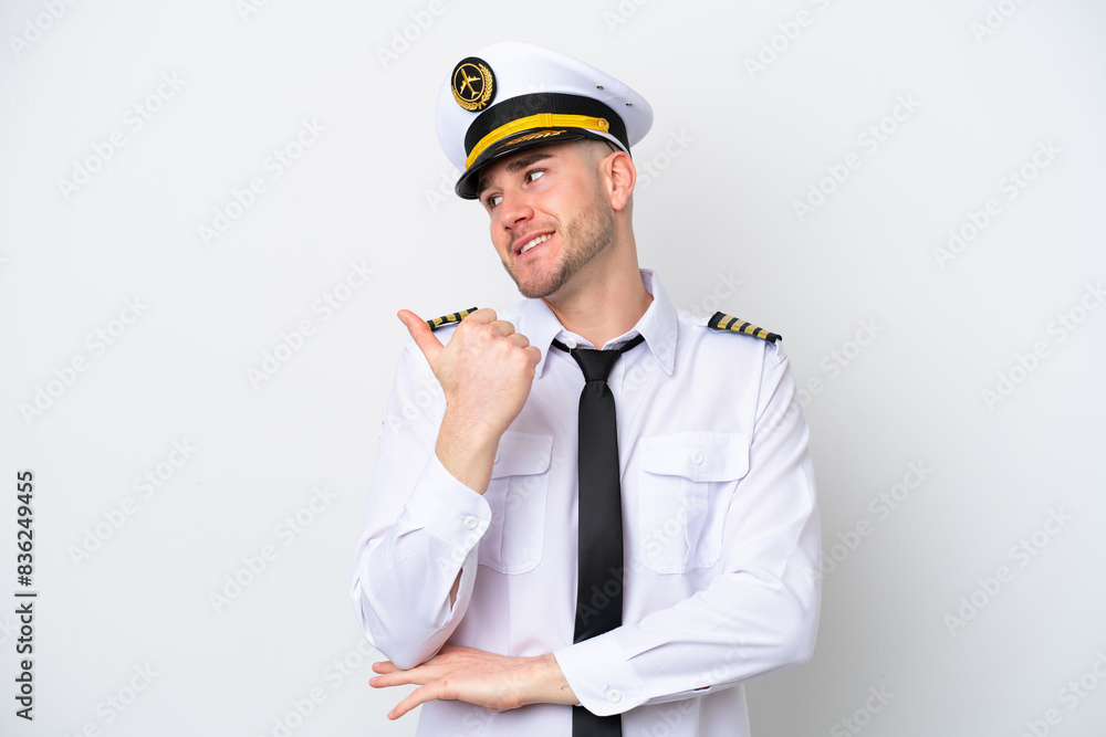Airplane caucasian pilot isolated on white background pointing to the side to present a product Airplane caucasian pilot isolated on white background pointing to the side to present a product