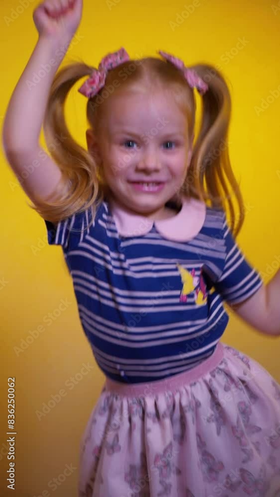 A little girl is enthusiastically playing the pop it game. Vertical video. Push Pop Fidget Toy. A happy child is playing a children's game on a yellow background. A little child is laughing and playin A little girl is enthusiastically playing the pop it game. Vertical video. Push Pop Fidget Toy. A happy child is playing a children's game on a yellow background. A little child is laughing and playin
