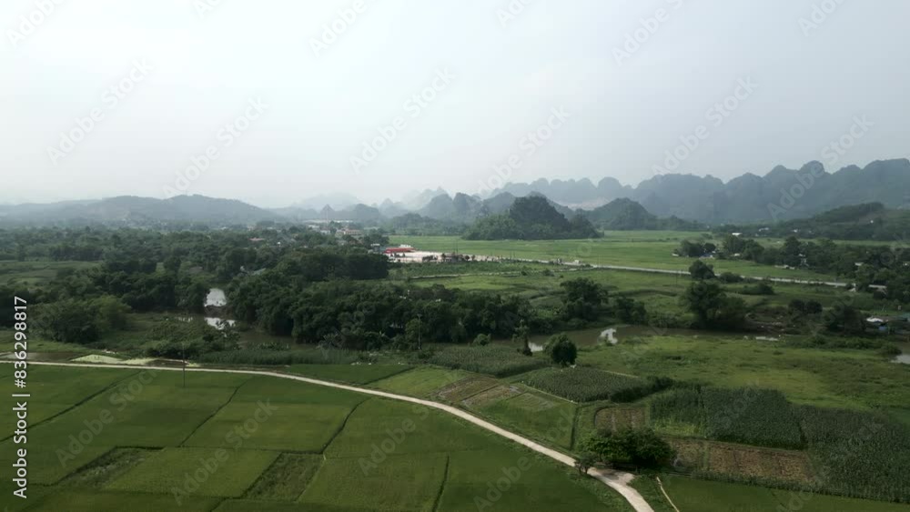 panoramic drone view of plain near farmland and river between mountains and road in hanoi vietnam panoramic drone view of plain near farmland and river between mountains and road in hanoi vietnam