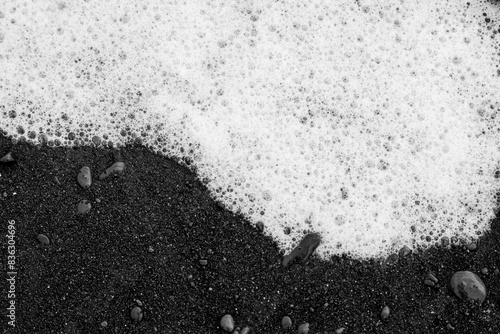 Sea foam on icelandic black sand beach