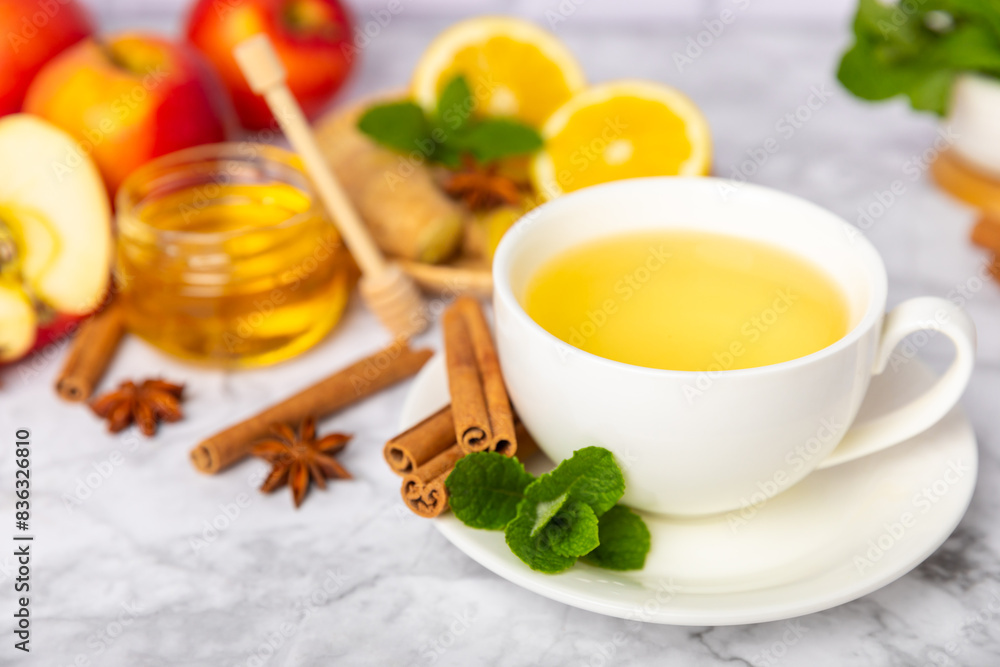 Fragrant hot tea with cinnamon stick and anise on a textured wooden background. A cup of hot tea with honey, lemon, mint and apples. Spicy tea with spices. Immunity tea. Health concept.Copy space. Fragrant hot tea with cinnamon stick and anise on a textured wooden background. A cup of hot tea with honey, lemon, mint and apples. Spicy tea with spices. Immunity tea. Health concept.Copy space.