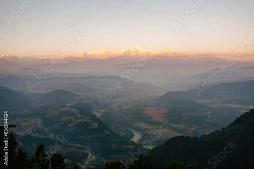 Stunning sunrise view over the misty valley of Bandipur, Nepal, with the majestic Himalayas illuminated in the distance.
