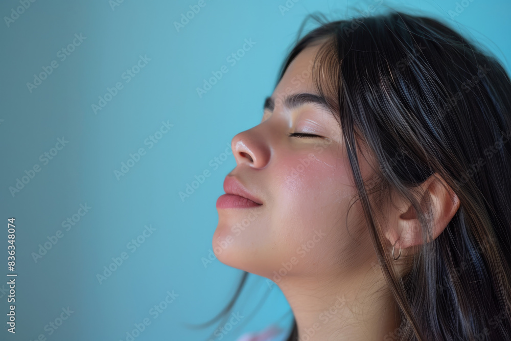 A close up of a woman's face with her eyes closed looking to a side A close up of a woman's face with her eyes closed looking to a side