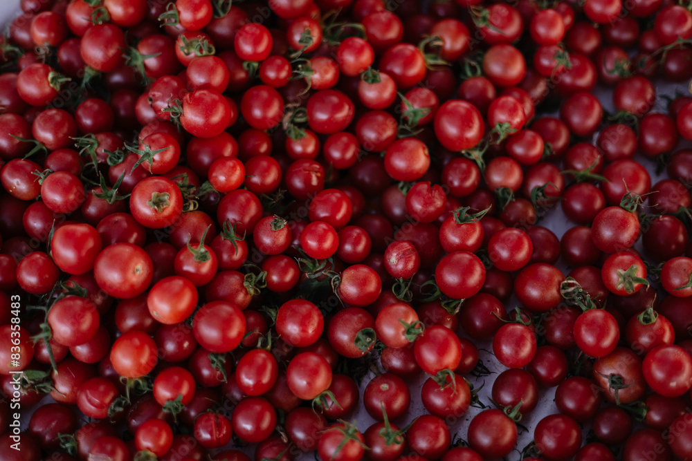 Many small red cherry tomatoes on a counter at a Turkish bazaar Many small red cherry tomatoes on a counter at a Turkish bazaar