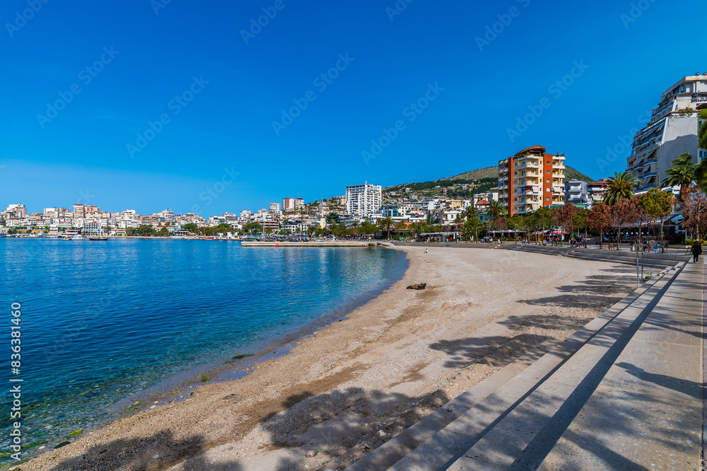 A view along the beach in the bay at Sarande in the morning in summertime