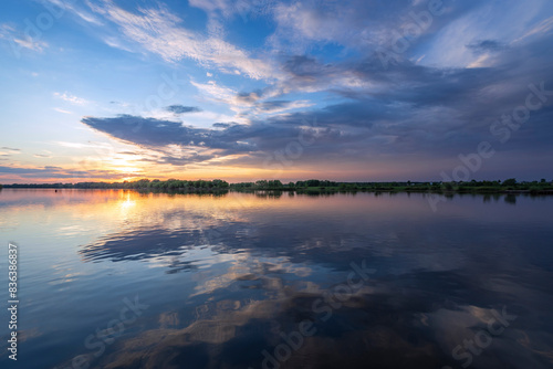 Wallpaper Mural The sun sets over a serene lake, casting a golden glow on the waters surface as the peaceful ripples gently sway. Torontodigital.ca