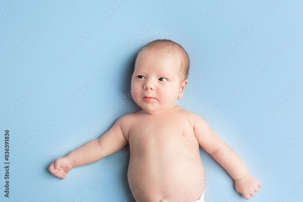 newborn baby lies on a blue background. portrait of a little boy newborn baby lies on a blue background. portrait of a little boy