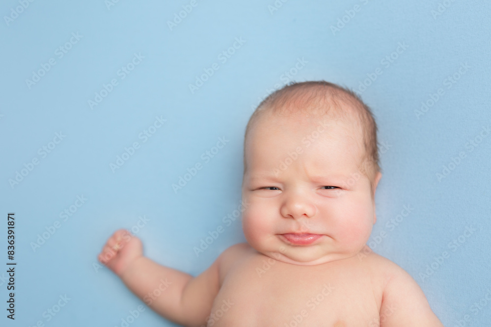 newborn baby lies on a blue background. portrait of a little boy newborn baby lies on a blue background. portrait of a little boy
