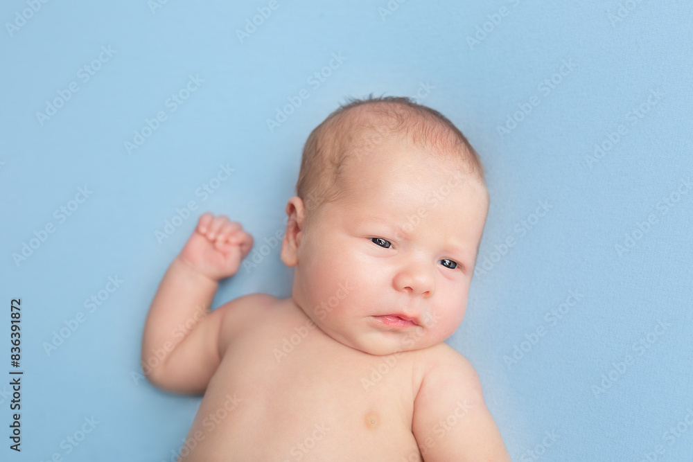 newborn baby lies on a blue background. portrait of a little boy newborn baby lies on a blue background. portrait of a little boy