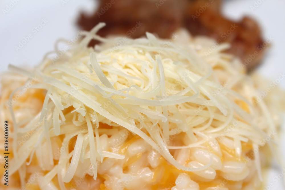 Risotto with grated cheese and meat. Closeup on risotto with meat in the background. food with a selective focus. Risotto with grated cheese and meat. Closeup on risotto with meat in the background. food with a selective focus.