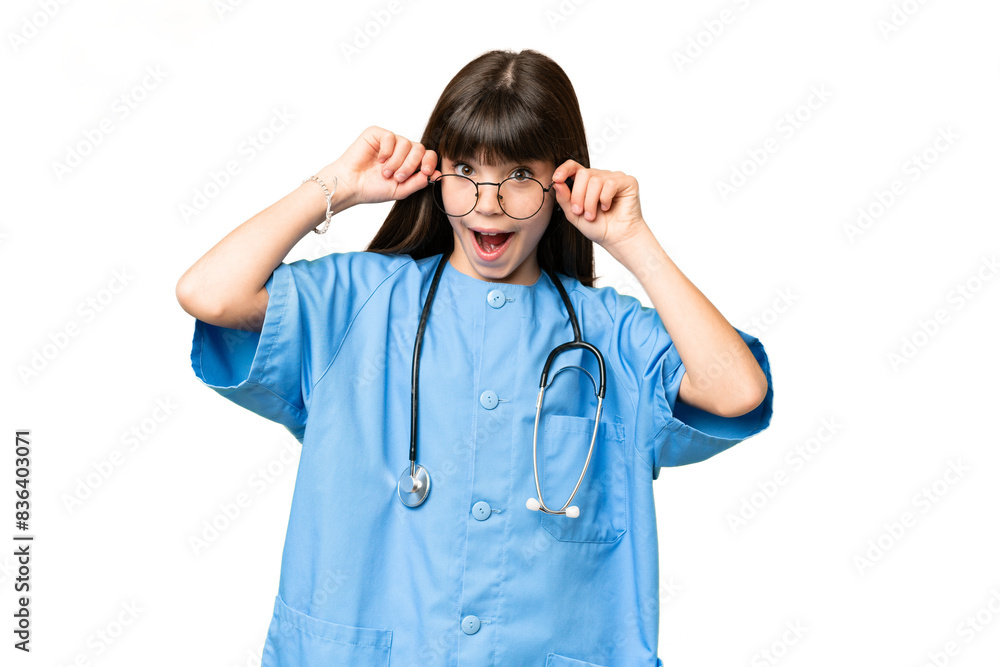 Little girl as a surgeon doctor over isolated chroma key background with glasses and surprised Little girl as a surgeon doctor over isolated chroma key background with glasses and surprised