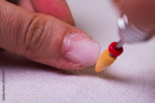 removing the gel polish coating from the nails with a ceramic cutter.