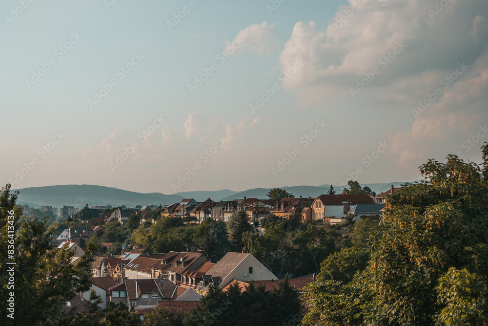 Obraz premium Orange brown tiled roof of the houses with solar panels. Traditional street. Amazing landscape with mountains and houses of Eger. Different size and colors building in Europe. Lifestyle of Hungary.