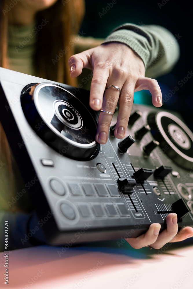 Girl filming mixing tutorial in home studio, showing examples of sampling on sound controller to viewers, close up shot. DJ showing high tech musical gear to interested fans Girl filming mixing tutorial in home studio, showing examples of sampling on sound controller to viewers, close up shot. DJ showing high tech musical gear to interested fans
