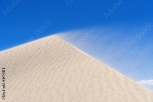 Sand Blowing Off The Crest Of A Dune