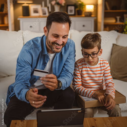 Father hold credit card buy online on tablet while son hold package