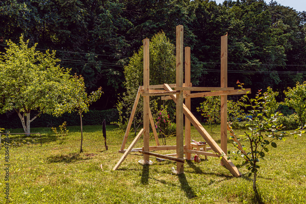A small playground. Children's wooden house. Children's swing A small playground. Children's wooden house. Children's swing