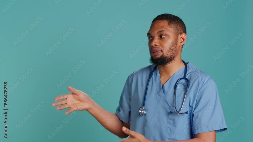 Portrait of african american nurse pointing hands towards empty space, doing advertising, talking with audience. Healthcare employee doing promotional ad, showing copy text, studio backdrop, camera A Portrait of african american nurse pointing hands towards empty space, doing advertising, talking with audience. Healthcare employee doing promotional ad, showing copy text, studio backdrop, camera A