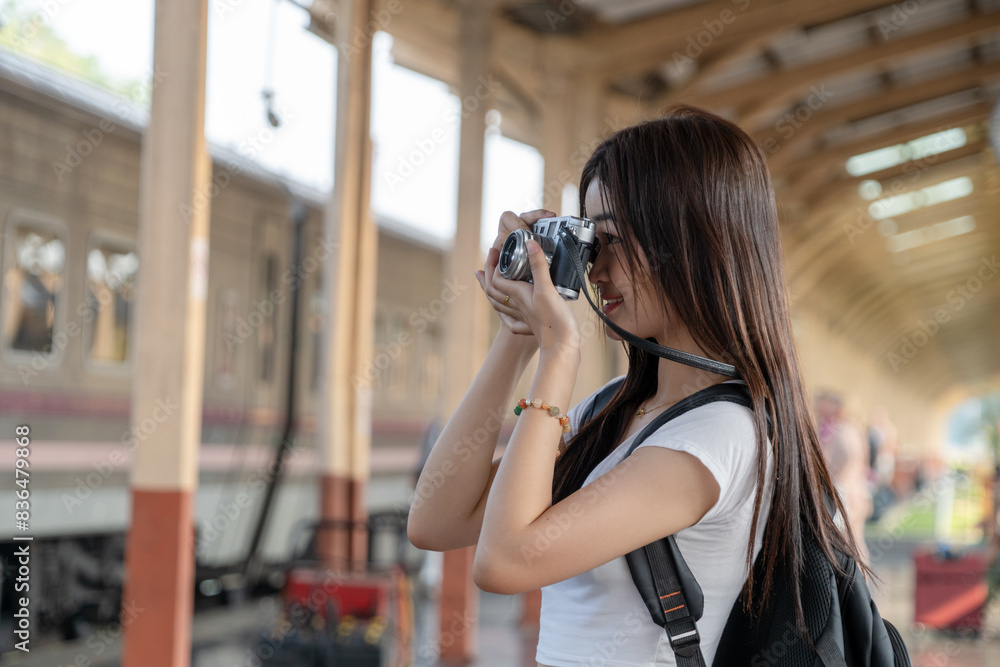 Young girl tourists smile and use camera take a photo travel photography on the train while waiting for the train to travel. Freedom active lifestyle concept. Young girl tourists smile and use camera take a photo travel photography on the train while waiting for the train to travel. Freedom active lifestyle concept.