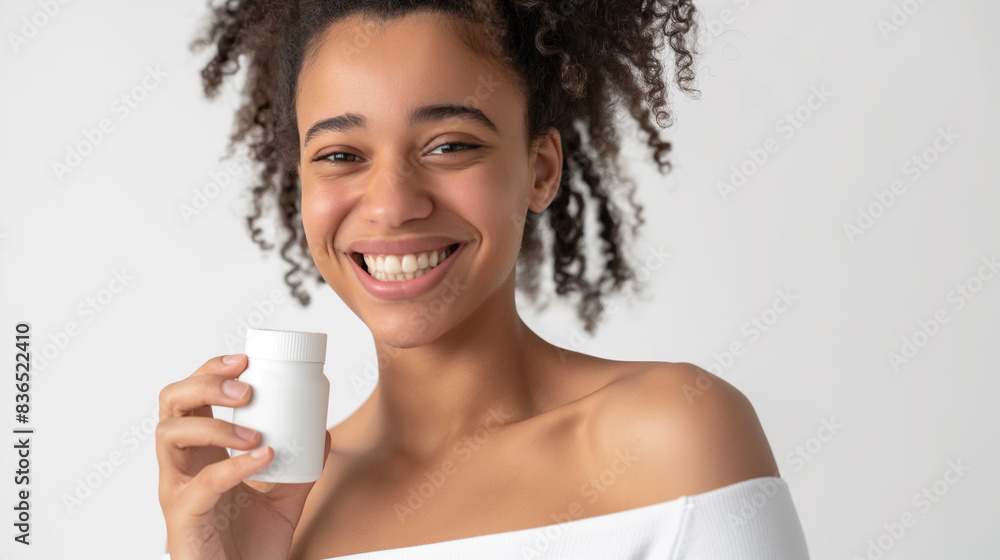 A smiling young Woman with a white jar in her hand on a white background. Photos for advertising medicines and biologically active additives. A smiling young Woman with a white jar in her hand on a white background. Photos for advertising medicines and biologically active additives.