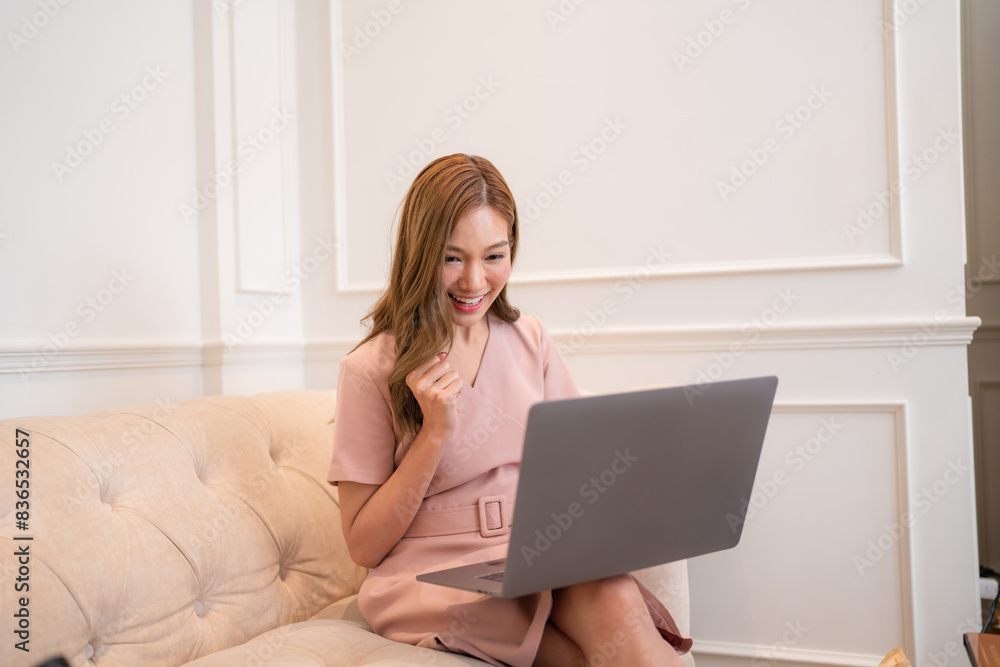 Happy and smiling businesswoman talking on cellphone and typing on laptop, office worker happy with achievement results, at work inside office building. Happy and smiling businesswoman talking on cellphone and typing on laptop, office worker happy with achievement results, at work inside office building.