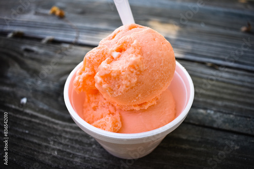 Valokuvatapetti orange sherbet on a wooden table