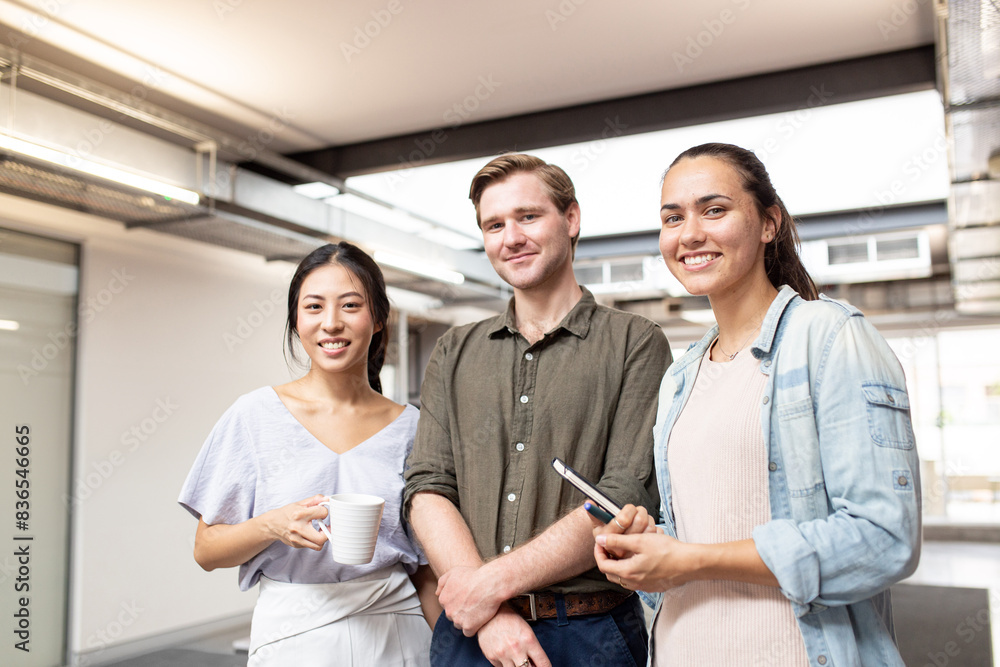 Three businesspeople smiling at the camera in an office Three businesspeople smiling at the camera in an office