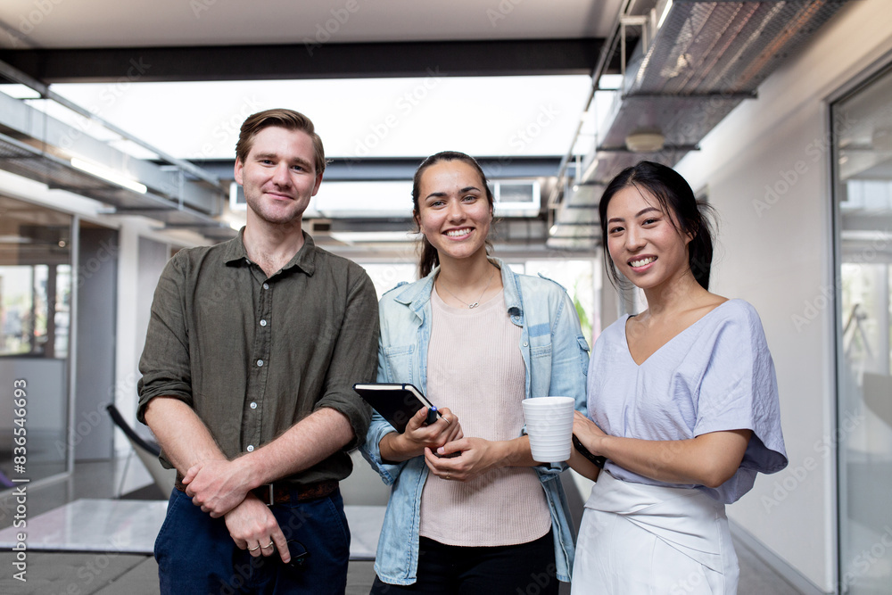 © Austockphoto - Three businesspeople smiling at the camera in an office