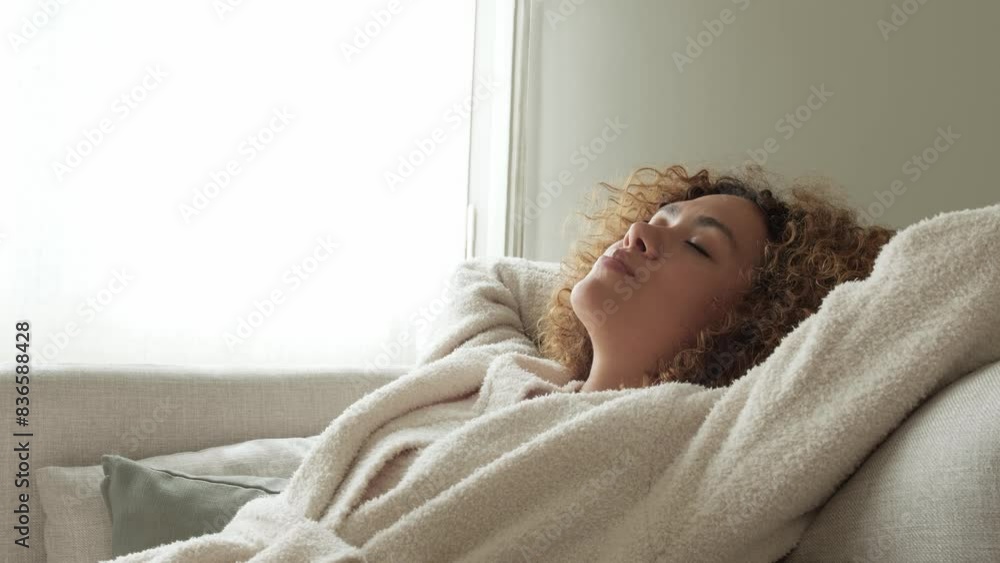 Slow motion 4k resolution video of happy multiracial woman relaxing on the sofa with arms behind the head. Slow motion 4k resolution video of happy multiracial woman relaxing on the sofa with arms behind the head.