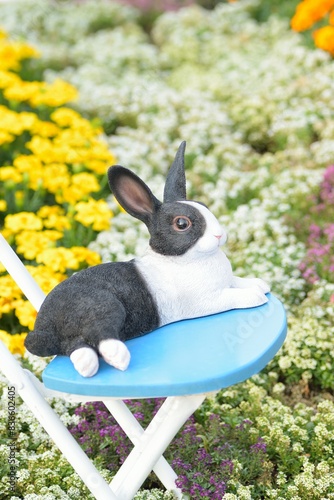 Statue of rabbit in colorful Spring flower background