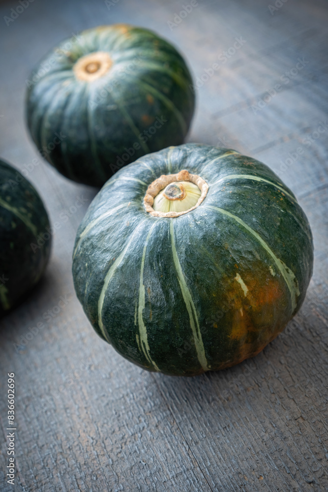 Green mini pumpkin on a wooden gray table, close-up, minimalism Green mini pumpkin on a wooden gray table, close-up, minimalism
