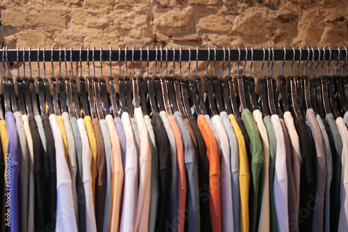 Colorful shirts displayed neatly on rack in clothing store, creating stylish assortment