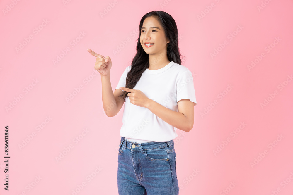 Happy smiling young woman wearing casual white t-shirt with shows hand pointing to the front, isolated on pink background. Happy smiling young woman wearing casual white t-shirt with shows hand pointing to the front, isolated on pink background.