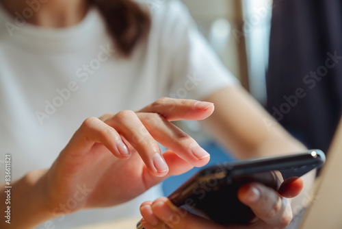 Hand holding smartphone and chatting online on mobile, During leisure time.
