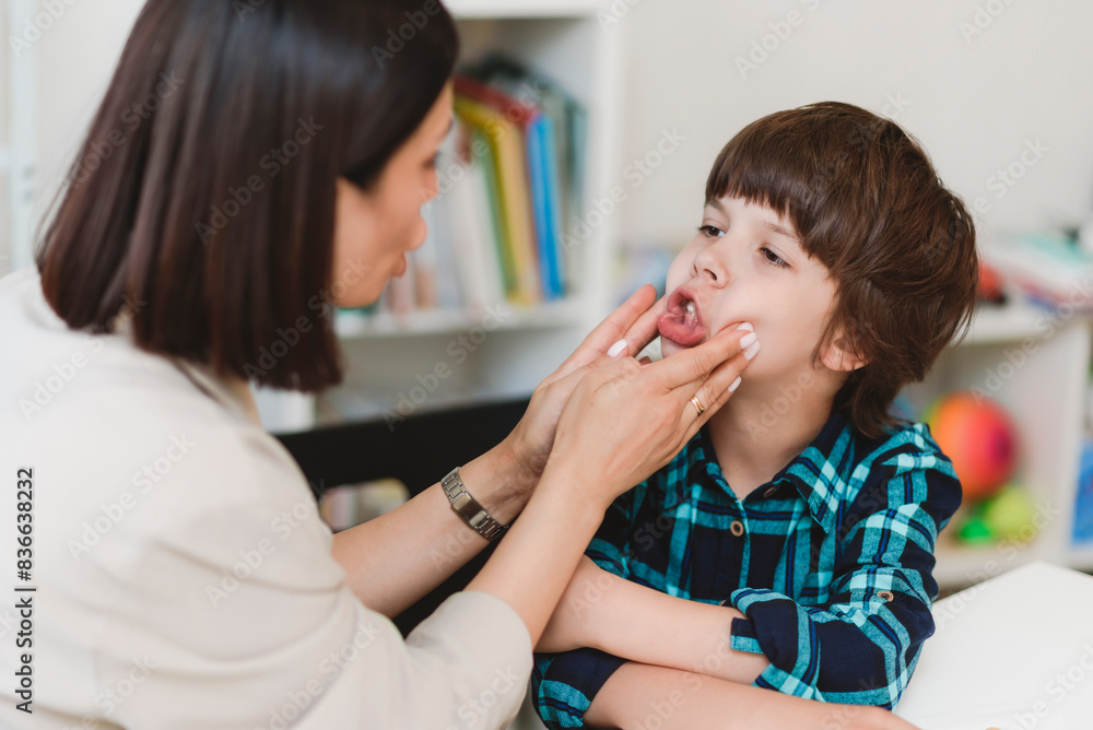 Woman speech therapist helps a boy correct the violation of his speech Woman speech therapist helps a boy correct the violation of his speech