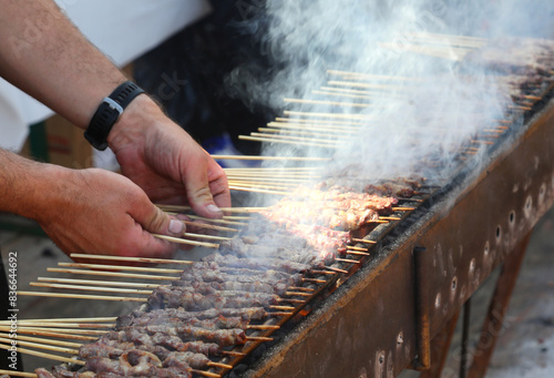 hands of chef and Grilled skewers of mutton or lamb called ARROSTICINI are a typical dish of Italy