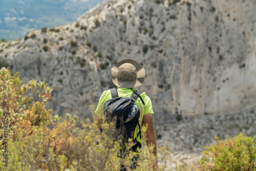 Male hiker walking on mountains on a summer day.