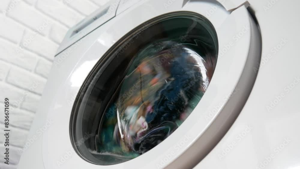 Close-up of a washing machine washing colorful clothes Close-up of a washing machine washing colorful clothes
