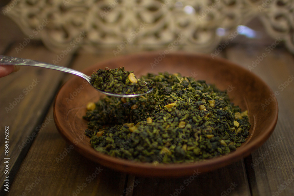 A clay plate with green fruit tea stands on a wooden table. A clay plate with green fruit tea stands on a wooden table.