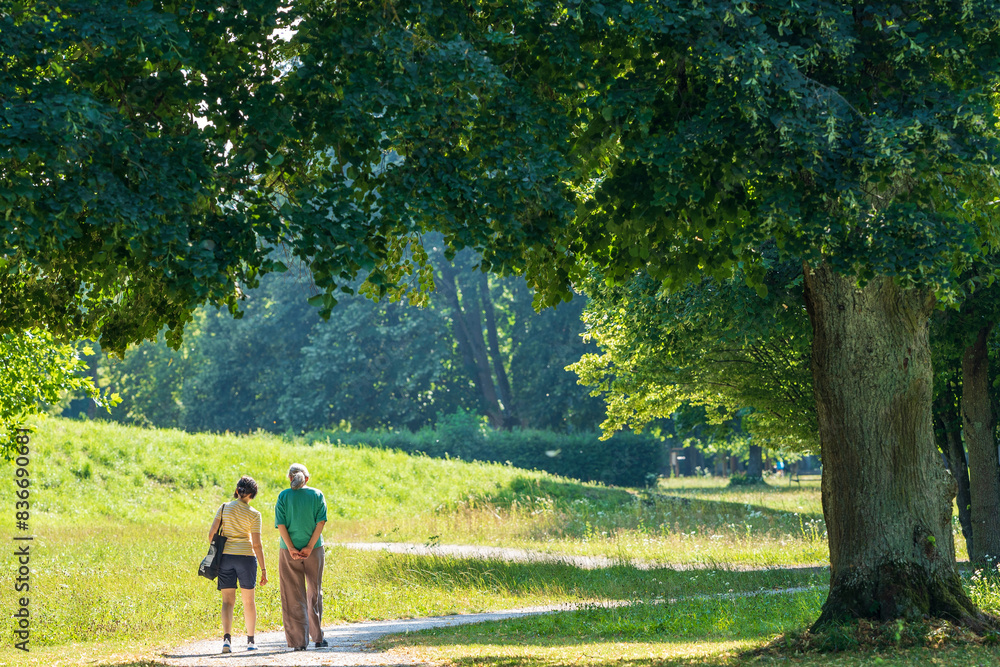 the two people are walking down the path together together,