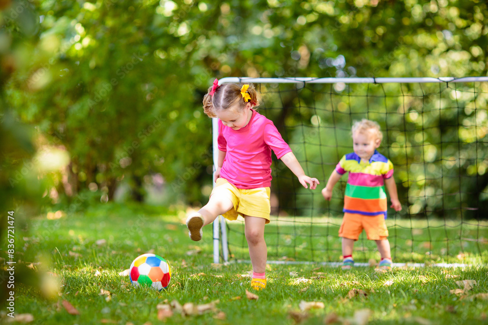 Obraz premium Kids play football. Child at soccer field.