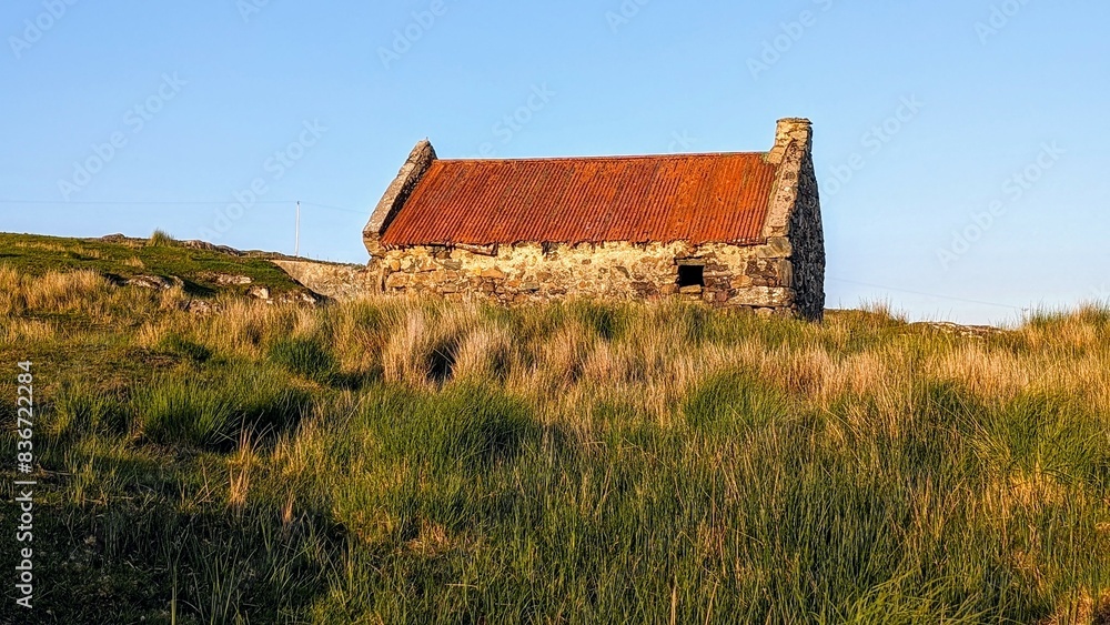 Beautiful landscape scenery with old rusty tin roof cottage on green hill at Connemara National park in County Galway, Ireland