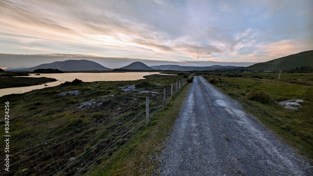 Empty rural road by lake and mountains at Connemara national park, Galway, Ireland