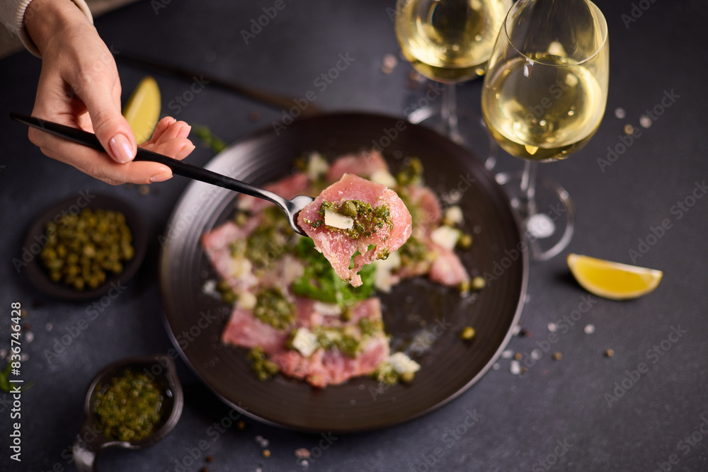 tuna carpaccio - slices of fresh raw tuna fillet on black ceramic plate tuna carpaccio - slices of fresh raw tuna fillet on black ceramic plate