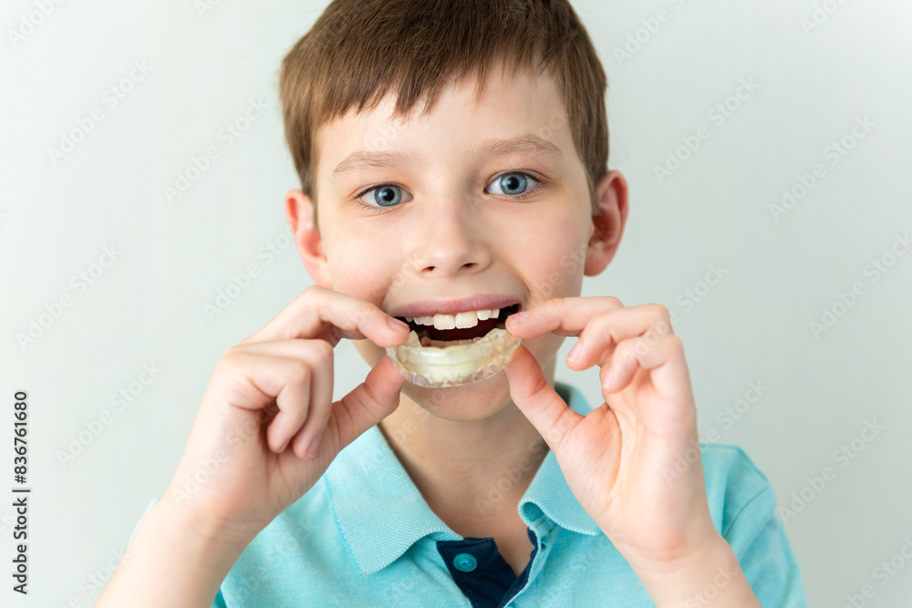 Dental care. Smiling Child boy with healthy teeth using removable clear braces aligner, orthodontic silicone trainer Dental care. Smiling Child boy with healthy teeth using removable clear braces aligner, orthodontic silicone trainer
