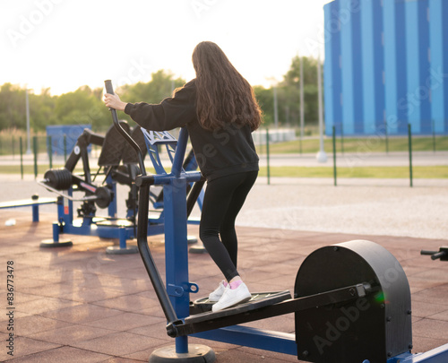Female Athlete Exercising on Outdoor Elliptical Machine, leg training day