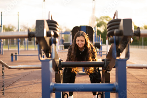 Woman Performing Deadlift Exercise at Outdoor Gym During Golden Hour