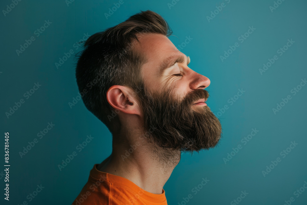 A close up of a man with beard and closed eyes looking to a side A close up of a man with beard and closed eyes looking to a side